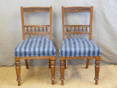 A pair of late 19thC/early 20thC dining chairs with carved and bobbin turned decoration