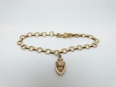 A 9ct gold bracelet and charm reading 'knock at my heart', 7.