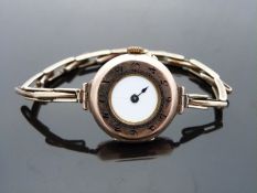 A 9ct gold ladies half hunter wristwatch with white enamel dial,