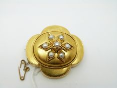 A Victorian yellow metal brooch set with seven pearls in a flower design,