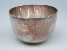 A modern Arts & Crafts style feature hallmarked Britannia standard tumbler or cup with hammered
