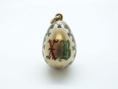 A silver Russian egg pendant with enamel geometric borders,