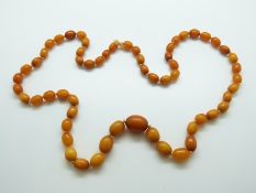 A Baltic amber necklace of 59 ovoid beads, the largest approximately, 34.2g, 1.9 x 1.