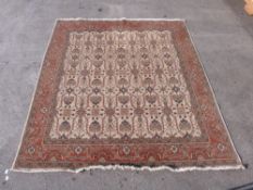 A cream wool rug with rust coloured border and geometric design,