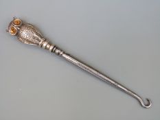 An Edward VII hallmarked silver handled novelty owl button hook with paste eyes,
