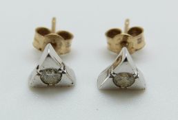 A pair of white gold earrings set with a diamond to each