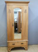 A satinwood Art Nouveau wardrobe with bevelled mirror door and single drawer below,