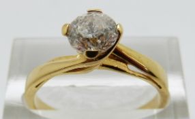 A yellow metal ring set with a modern round brilliant cut diamond of approximately 0.