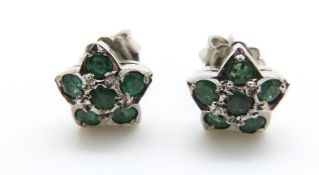 A pair of white metal earrings set with emeralds