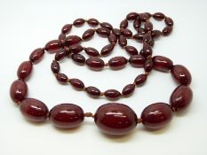 A cherry amber necklace of 57 graduated ovoid beads, the largest approximately 28x22mm, 61g,
