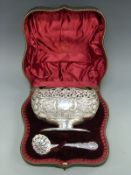 An Edward VII hallmarked silver sugar bowl and sifter spoon with embossed and pierced decoration,