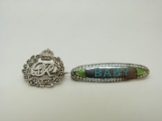 A Charles Horner silver baby brooch set with blue and green enamel reading 'Baby' and a silver GR