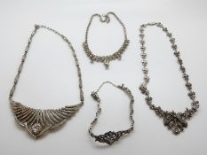 A silver necklace set with marcasite, a white metal necklace set with paste,