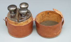 A leather cased travelling or hunting set comprising three bottles, each with hallmarked silver lid,