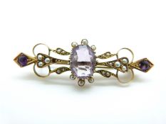 An Edwardian brooch set with an oval cut amethyst surrounded by seed pearls with further round cut