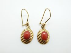 A pair of 18ct gold earrings set with a coral cabochon to each, 3.