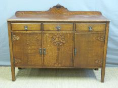 An oak sideboard with foliate decoration to doors,