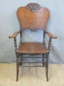 A carved oak armchair with solid seat and back