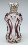 An overlaid cut glass scent bottle with white metal embossed top,