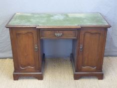 A twin pedestal leather inset break front desk,