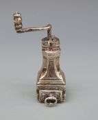 A white metal novelty coffee grinder with rotating mechanism marked with Medusa-Oro,