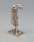 A white metal novelty coat rack with hat and articulated coat, marked with star 175 AR 925,