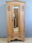 A satinwood Art Nouveau wardrobe with bevelled mirror door and single drawer below,