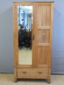 A satinwood wardrobe with bevelled mirror door and single drawer below,