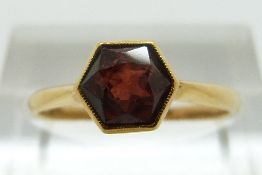 A 22ct gold ring set with a hexagonal cut garnet, size L/M, 2.