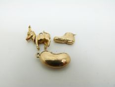 A 9ct gold donkey charm with articulated head and tail, a 9ct gold boot and a 9ct gold bean, 4.
