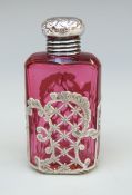 A Victorian cranberry glass scent bottle with silver top and pierced silver decoration,