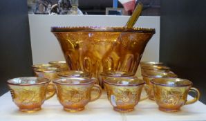 A carnival glass pedestal punch bowl set with cups, ladle and hangers,