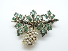 A silver gilt brooch set with emeralds and pearls in the form of a grape vine