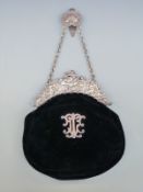 An Edward VII hallmarked silver mounted velvet evening bag decorated with cherubs and with applied