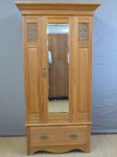 A satinwood Art Nouveau wardrobe with bevelled mirror door and single drawer below,