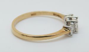 An 18ct gold ring set with three princess cut diamonds totalling approximately 0.