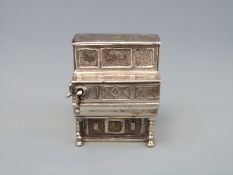 A white metal novelty barrel piano or organ with rotary handle, marked with Medusa-Oro,