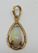 A 14k gold pendant set with a pear cut opal cabochon