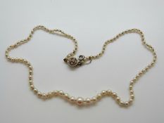 A single strand of 28 cultured and 76 natural pearls,