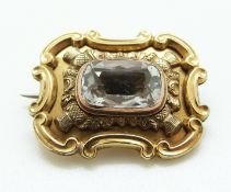 A Victorian brooch set with an aquamarine in a foiled setting within thistle border,
