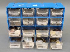 An amateur collection of world coins in a small collector's cabinet, includes USA, Canada, Germany,