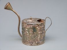 A white metal novelty watering can with embossed decoration, stamped to base with 930 silver marks,