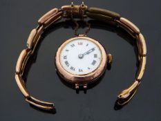 A 9ct gold ladies wristwatch with black hands and Roman numerals, gilt dot minute markers,