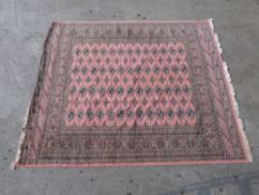 A Pakistan made 100% wool pink ground Afghan rug,
