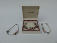 Three silver bracelets marked Pandora with various charms in Pandora box