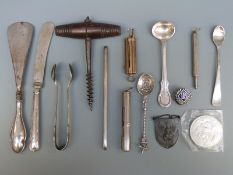 A collection of items to include corkscrew, white metal spoons,