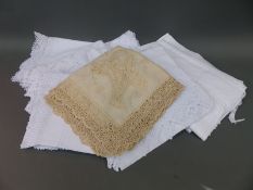 A collection of linen and lace to include tablecloths and lace edged pillowcases