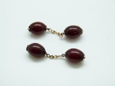 A pair of Victorian cherry amber cufflinks with yellow metal fittings,