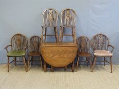 An oak drop leaf table and six (4+2) wheel back chairs, width of table 90cm,