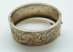 A large Victorian silver bangle with applied gold swallow design
